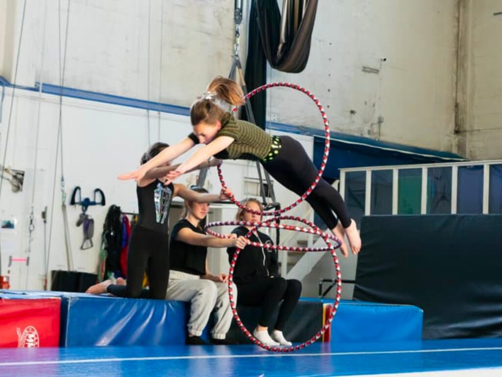 A person jumping through a hula hoop at the gym.