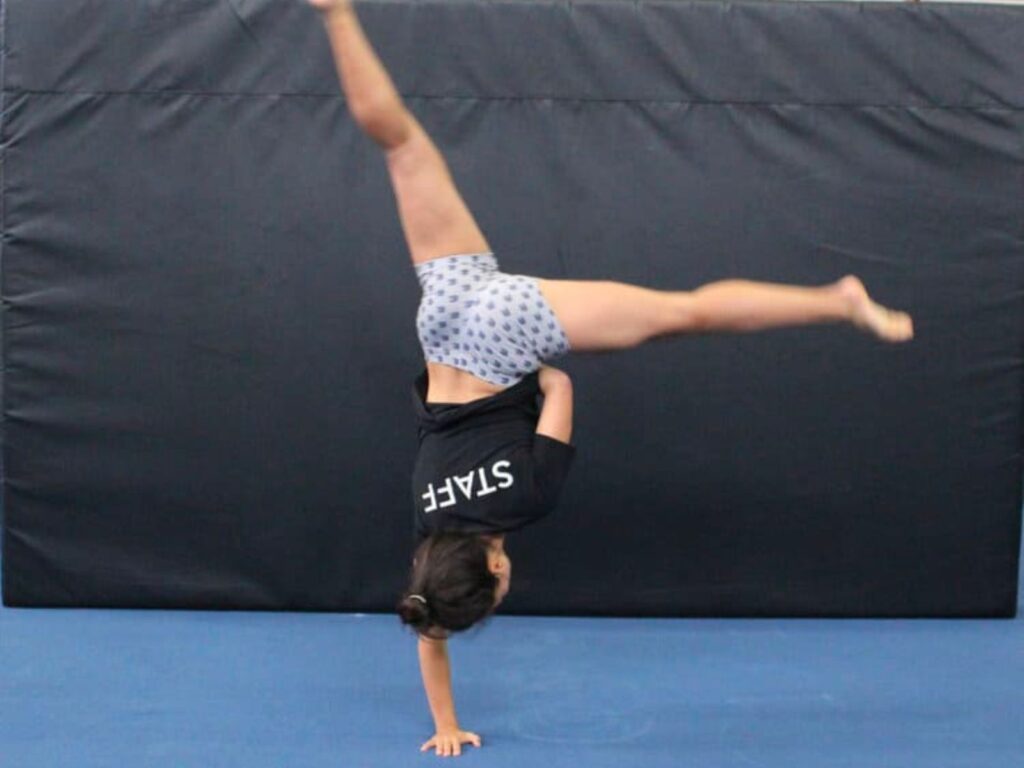 AcroSports coach tumbling with one hand.