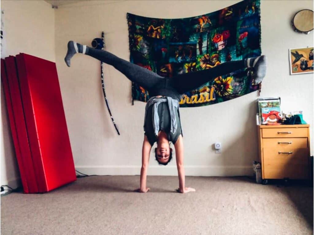 AcroSports coach doing a handstand in a room