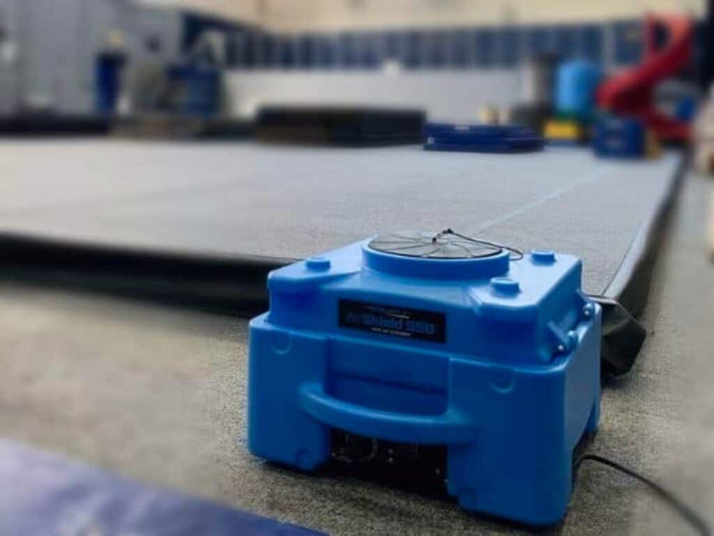 a blue portable air purifier sitting on the floor