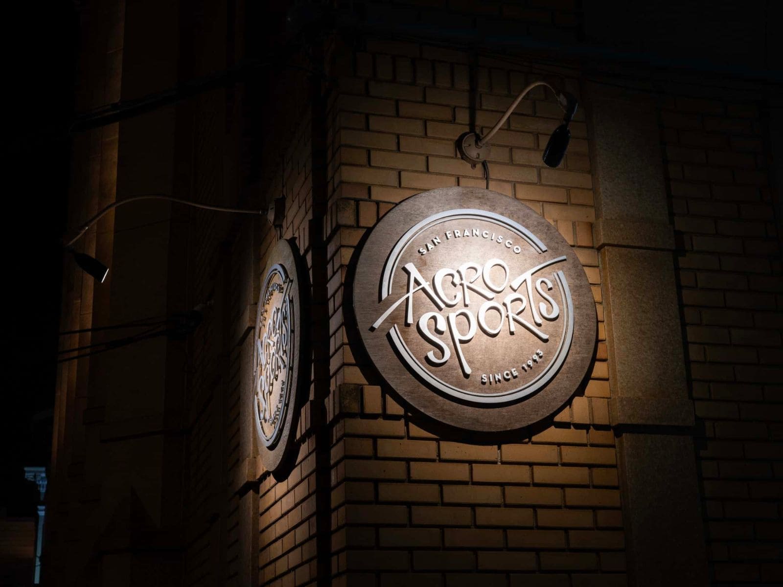 a sign on the side of a brick building at night