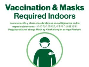 Covid compliance sign: masks and vaccination required.