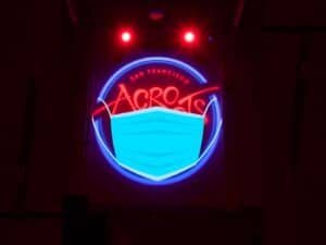 AcroSports neon sign with a facemask on it.